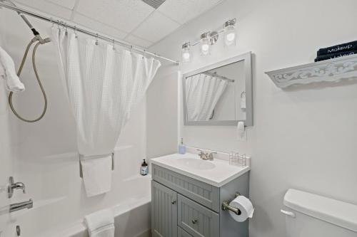 a white bathroom with a sink and a mirror at Serra Stays - "Casa di Cresta" in Lake Lure