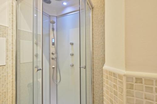 y baño con ducha y puerta de cristal. en Maison Romantique, en Santa Maria di Castellabate