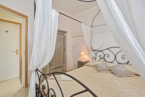 1 dormitorio con 1 cama grande con dosel en Maison Romantique, en Santa Maria di Castellabate