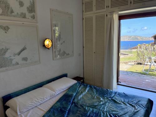 - une chambre avec un lit et une grande fenêtre dans l'établissement SAN TEODORO PUNTA EST MONOLOCALE VISTA MARE, à Cap Coda Cavallo