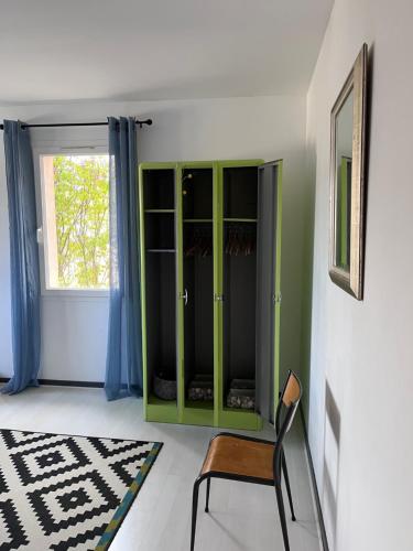 a green cabinet in a room with a chair at Villa les Rosiers in Tallard