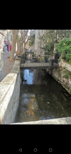 ein kleiner Fluss mit einer Brücke in einer Stadt in der Unterkunft Studio Centre ville les halles in Avignon