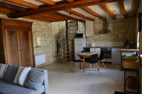 eine Küche mit einem Sofa und einem Tisch in einem Zimmer in der Unterkunft La Grange de l'Olive in Chinon