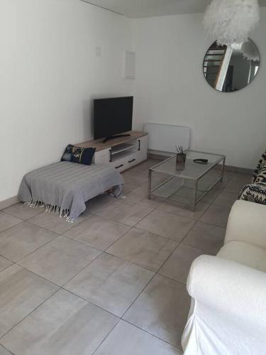 a living room with a tv and a tiled floor at Appartement duplex 4 personnes in Loiré-sur-Nie