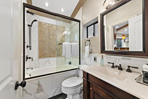 a bathroom with a sink and a tub and a toilet at Villa Palazzo D'Stella at the Retreat in Laguna Beach
