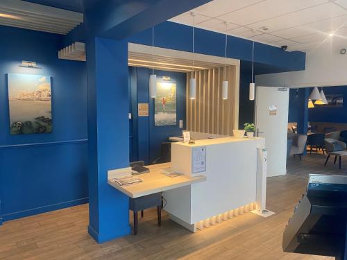 Cette chambre est dotée de murs bleus et d'un bureau. dans l'établissement Hôtel Villa Des 2 Caps, à Wimereux