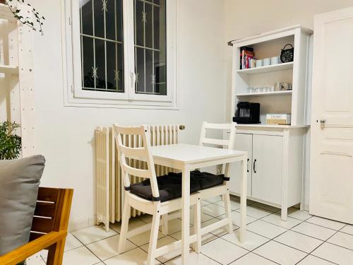 a kitchen with a white table and two chairs at Sweet Home - 55m2 appartment, garden, swimming pool, parking in Toulouse