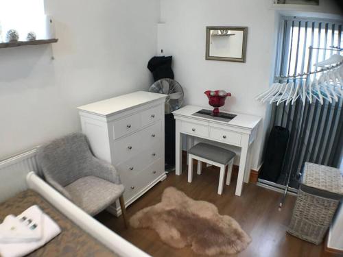 a bedroom with a desk and a chair and a dresser at 1 Bed Charming Peak District Cottage Barn Near Alton Towers, Polar Bears, Chatsworth House in Leek