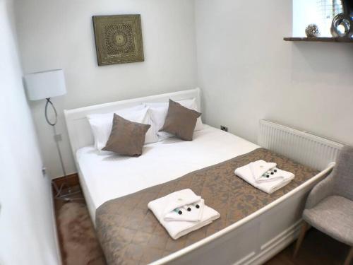 a bedroom with a bed with two towels on it at 1 Bed Charming Peak District Cottage Barn Near Alton Towers, Polar Bears, Chatsworth House in Leek