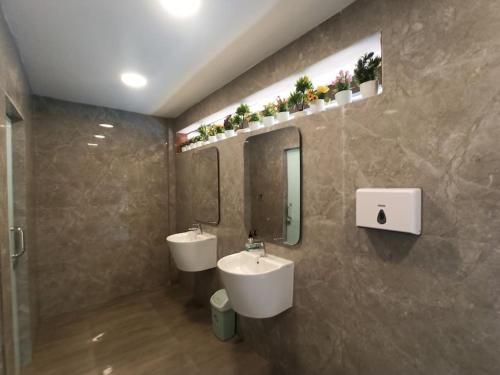 uma casa de banho com 2 lavatórios e um espelho em Royal Apartment Makassar perfect for family 45m 2BR near Mall Panakkukang Downtown em Pampang