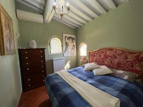 a bedroom with a bed and a chandelier at Il Fiorino di Badia in Badia A Passignano
