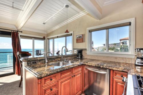 uma cozinha com um lavatório e algumas janelas em Villa Roma at the Retreat in Laguna Beach em Laguna Beach