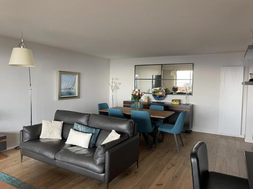 - un salon avec un canapé et une table à manger dans l'établissement Appartement avec vue mer panoramique, à Mandelieu-la-Napoule