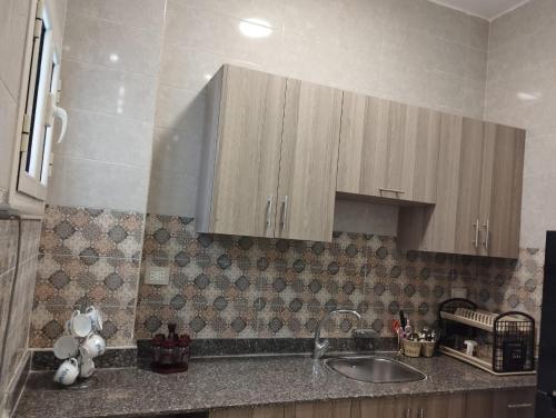 a kitchen with a sink and wooden cabinets at Hurghada's Marina view in Hurghada