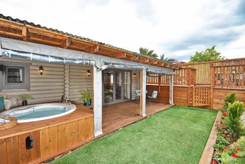 a backyard with a hot tub on a wooden deck at Suites Tuia in Had Nes