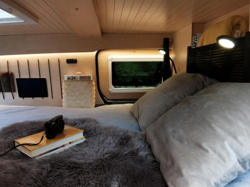 um quarto com uma cama grande e uma janela em OsloCampervan em Oslo