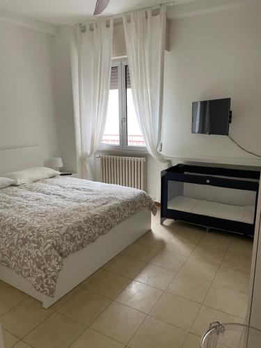 a bedroom with a bed and a flat screen tv at Viale Pascoli Due in Cesenatico