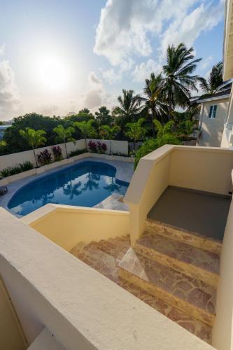 a view of a swimming pool from the balcony of a house at Villa Seru JanThiel in Jan Thiel
