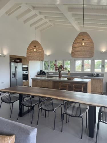 a kitchen with a large wooden table and chairs at Villa Seru JanThiel in Jan Thiel
