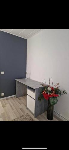 an office with a desk with a vase of flowers at Comfy Cozy Room in beautiful home in Luleå