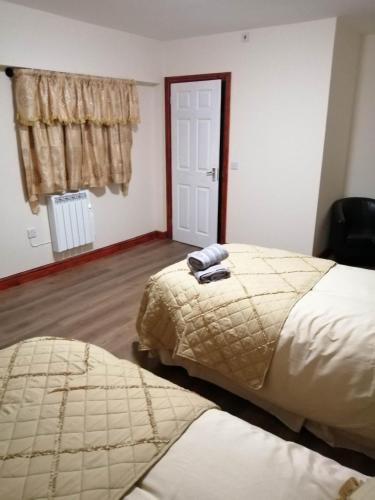 1 dormitorio con 2 camas, ventana y puerta en The Old Cart Shed en Lenwade
