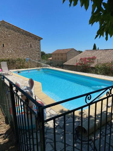 - une piscine avec une personne assise sur une chaise à côté dans l'établissement Mas avec piscine, à La Bastide-dʼEngras