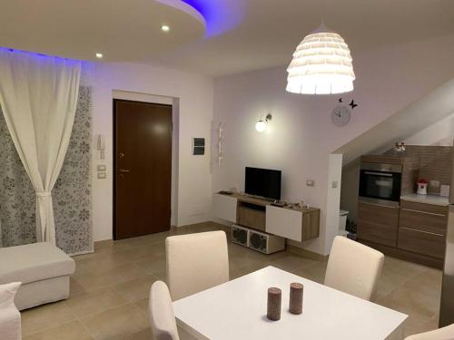 uma sala de estar com uma mesa branca e cadeiras em Appartamento al mare - Porto Recanati em Porto Recanati