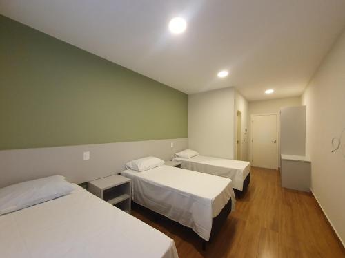 アグアス・デ・リンドイアにあるPousada Thermas das Montanhasの病院(ベッド2台付)、テーブル2台付きの部屋