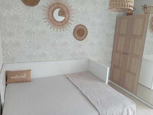 1 dormitorio con cama blanca y pared en Chambre nature chez l'habitant, en Estrasburgo