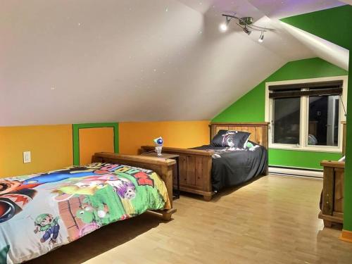 two beds in a room with green and yellow walls at PANORAMA DE LA DETENTE-BORDURE DE FLEUVE (309418) in Saint-Laurent-de-l'ile d'Orleans