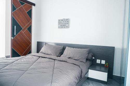 1 dormitorio con 1 cama grande y cabecero de madera en Merryland Villa Bali en Jimbaran