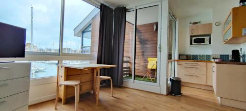 Il comprend une cuisine avec une table et un bureau avec une fenêtre. dans l'établissement Le loft-boat, à Deauville