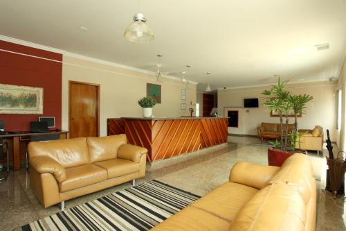 - un salon avec un canapé et des chaises dans l'établissement Candeias Hotel, à Batatais