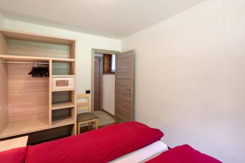 - une chambre avec un lit rouge et un placard dans l'établissement Baita Belvedere app. Mottolino - Appartamenti Abar, à Livigno