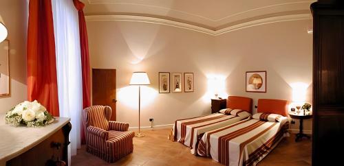 una camera d'albergo con letto e sedia di Palazzo Alfani - Residenza d'Epoca a Firenze