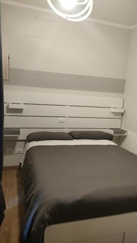 un letto in una stanza con una luce sopra di essa di Appartamento indipendente in Franciacorta a Passirano