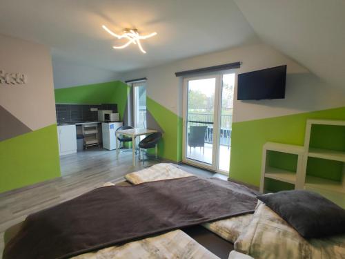 アルショーウルシュにあるKikapcs apartmanの緑の壁のベッドルーム1室、ベッド1台、デスクが備わります。