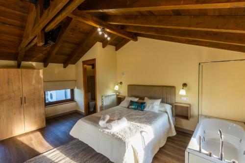 1 dormitorio con 1 cama grande y bañera en Casona del Campo en Navia