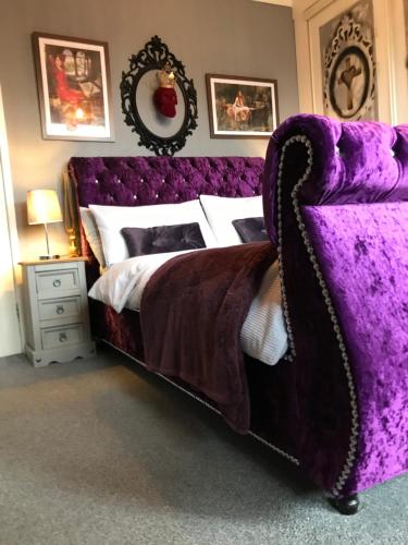 a bedroom with a purple bed and a purple couch at The Beach House South - Blackpool - Entire Holiday Home in Blackpool