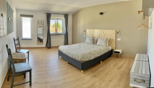a bedroom with a bed and a chair at The Globetrotter's Inn in Ericeira