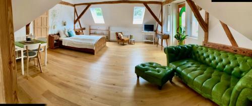 a living room with a green couch and a bed at derHofRat in Litzelsdorf