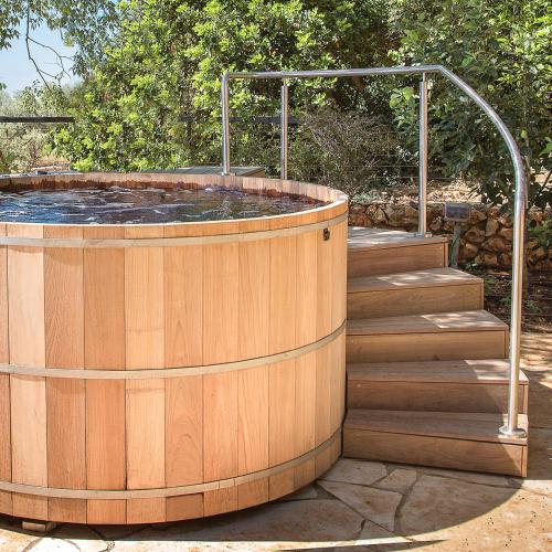 a hot tub with a wooden deck and stairs at Mizpe Hayamim by Isrotel Exclusive in Rosh Pinna