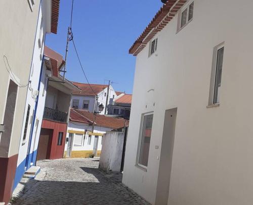 an alley in a town with white buildings at Vivenda do Américo in Juncal