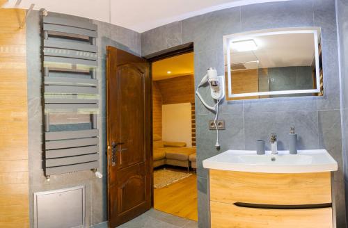 y baño con lavabo y espejo. en Conacul Drahneilor, en Ruscova