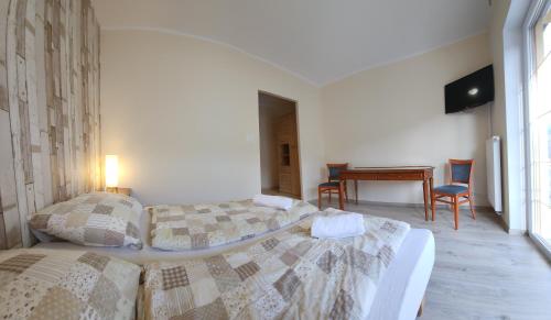 two beds in a room with a table and chairs at Willa Sielanka in Karpacz