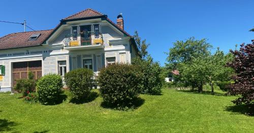 a blue and white house with bushes in the yard at derHofRat in Litzelsdorf