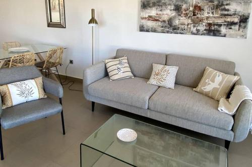 uma sala de estar com um sofá e uma mesa em Acogedor apartamento con piscina em Águilas