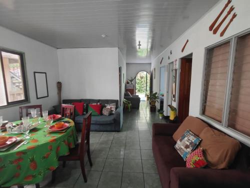 un soggiorno con tavolo e divano di Tortuguero Casa de Playa Green House a Tortuguero