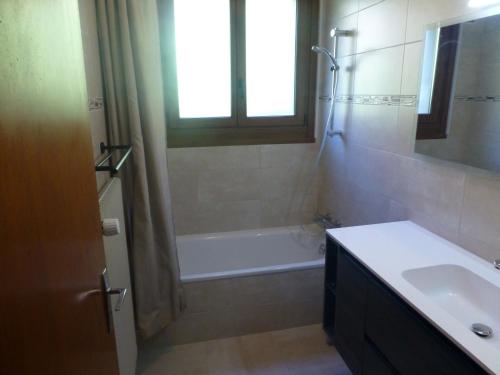 a bathroom with a tub and a sink and a shower at Le Fayet d'en haut in Abondance