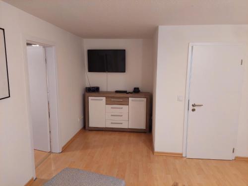 an empty living room with a television and a door at Wohnung im Dreistädteeck in Nürnberg